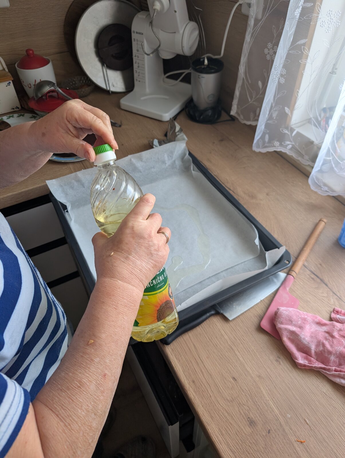 Drizzling a little oil onto the baking paper lining the tray